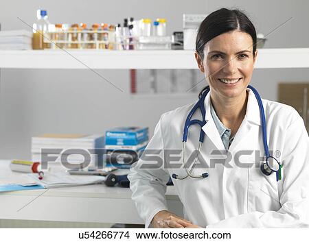 Picture - Doctor at desk awaiting patient. Fotosearch