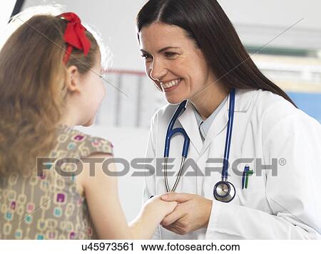 Stock Image - Doctor bonding with young girl during consultation. Fotosearch