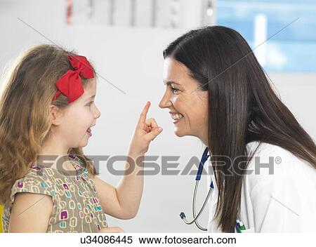 Stock Photography - Doctor bonding with young girl during consultation. Fotosearch