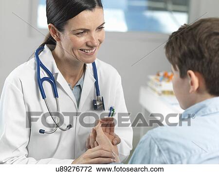 Doctor checking pulse of young boy in clinic View Large Photo Image Stock Image - Doctor checking pulse of young boy in clinic. Fotosearch