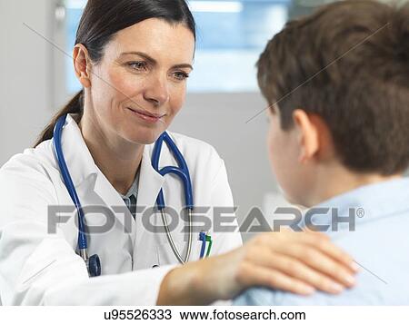 Doctor comforting young boy in clinic View Large Photo Image Stock Image - Doctor comforting young boy in clinic. Fotosearch