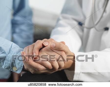 Doctor comforting young boy in clinic View Large Photo Image Stock Photo - Doctor comforting young boy in clinic. Fotosearch
