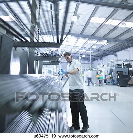 Engineer inspecting steel rods in factory View Large Photo Image Stock Photo - Engineer inspecting steel rods in factory. Fotosearch