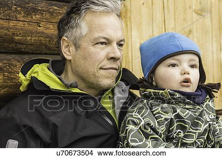 "Father and son sitting together, outdoors, looking away" View Large Photo Image Picture - "Father and son sitting together, outdoors, looking away". Fotosearch