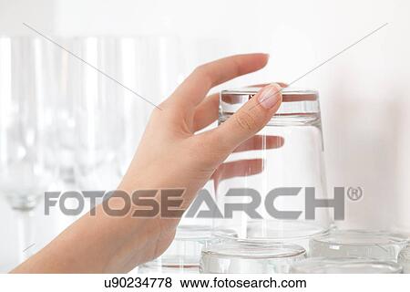 Stock Photo - Female hand picking up empty drinking glass. Fotosearch