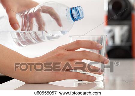 Female hands pouring bottled water into glass View Large Photo Image Stock Photo - Female hands pouring bottled water into glass. Fotosearch