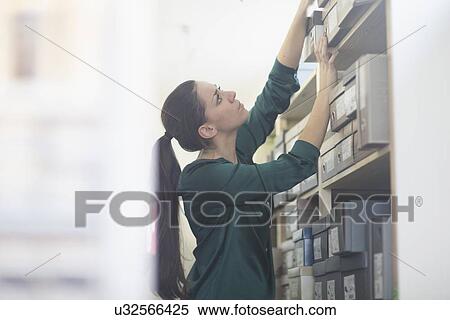 Female sales assistant reaching for shoe box in shoe shop stockroom View Large Photo Image Stock Photography - Female sales assistant reaching for shoe box in shoe shop stockroom. Fotosearch