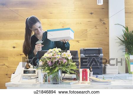 Female sales assistant using barcode reader on shoe box in shoe shop View Large Photo Image Picture - Female sales assistant using barcode reader on shoe box in shoe shop. Fotosearch