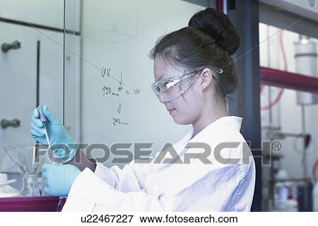 Female scientist in lab pipetting sample View Large Photo Image Stock Photo - Female scientist in lab pipetting sample. Fotosearch