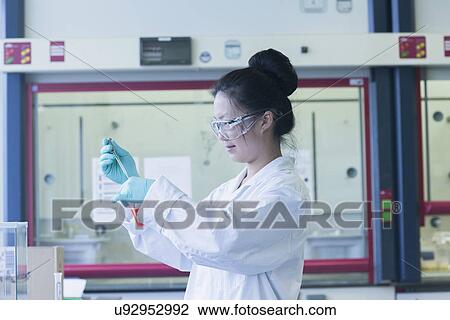 Female scientist in lab pipetting sample into lab beaker View Large Photo Image Stock Image - Female scientist in lab pipetting sample into lab beaker. Fotosearch