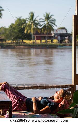 "Female tourist sunbathing on Mekong houseboat, Don Det, Laos" View Large Photo Image Stock Image - "Female tourist sunbathing on Mekong houseboat, Don Det, Laos". Fotosearch