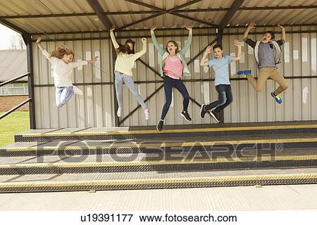 Five boys and girls jumping mid air in stadium stand View Large Photo Image Stock Photo - Five boys and girls jumping mid air in stadium stand. Fotosearch