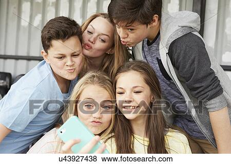 Five boys and girls making faces for smartphone selfie in shelter View Large Photo Image Stock Photo - Five boys and girls making faces for smartphone selfie in shelter. Fotosearch