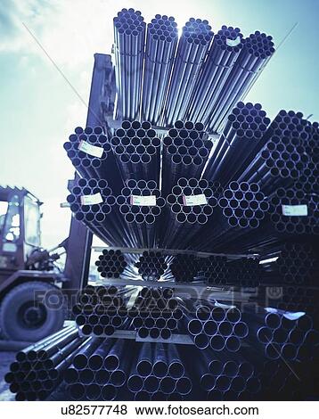 Stock Photo - "Forklift truck moving steel pipes in port, Grimsby, England, United Kingdom". Fotosearch