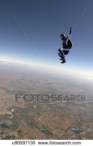 Stock Photography - Freeflying skydiver in blue sky. Fotosearch