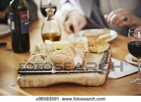 Stock Image - "Freshly baked bread on breadboard, close up". Fotosearch