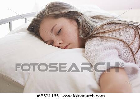 Stock Photography - Girl lying on bed asleep. Fotosearch