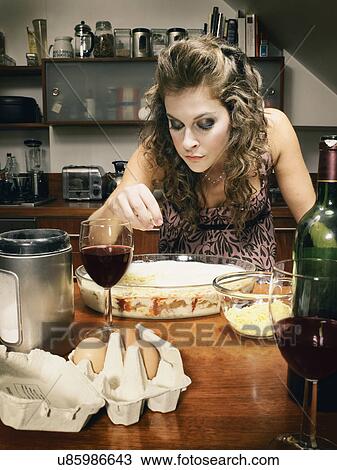 Glamorous young woman sprinkling cheese on food dish in kitchen View Large Photo Image Stock Image - Glamorous young woman sprinkling cheese on food dish in kitchen. Fotosearch