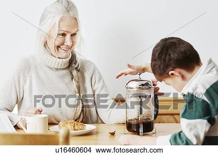 Picture - Grandmother and grandson making coffee in cafetiere. Fotosearch