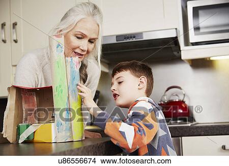 Grandmother and grandson making cardboard model View Large Photo Image Picture - Grandmother and grandson making cardboard model. Fotosearch