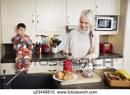 "Grandmother making coffee, grandson sitting on kitchen counter" View Large Photo Image Stock Photography - "Grandmother making coffee, grandson sitting on kitchen counter". Fotosearch