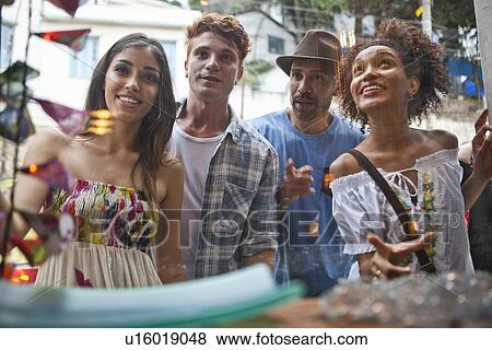 Stock Photo - Group of friends looking in shop window. Fotosearch