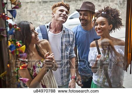 Group of friends looking in shop window View Large Photo Image Stock Photo - Group of friends looking in shop window. Fotosearch