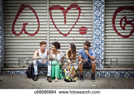 "Group of friends, sitting on ledge, talking" View Large Photo Image Picture - "Group of friends, sitting on ledge, talking". Fotosearch