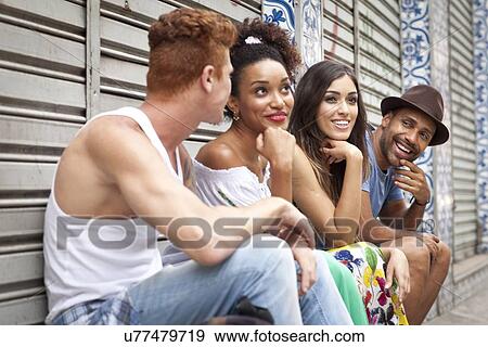 "Group of friends sitting together, laughing and smiling" View Large Photo Image Stock Photo - "Group of friends sitting together, laughing and smiling". Fotosearch