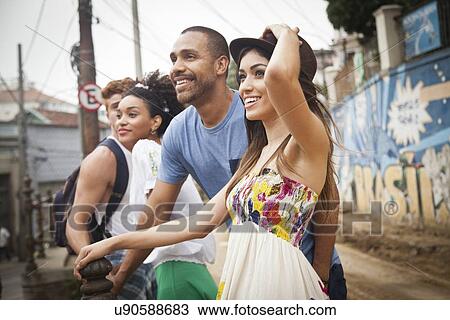 "Group of friends standing together, looking away, smiling" View Large Photo Image Stock Image - "Group of friends standing together, looking away, smiling". Fotosearch