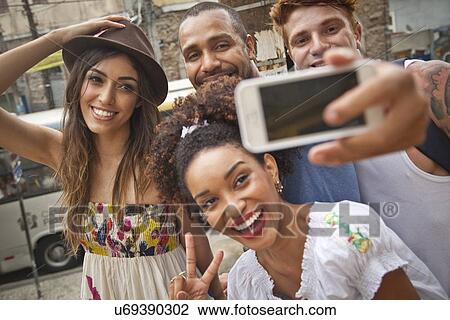 "Group of friends taking self portrait, using smartphone" View Large Photo Image Stock Image - "Group of friends taking self portrait, using smartphone". Fotosearch