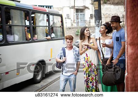 Picture - Group of friends walking along street together. Fotosearch
