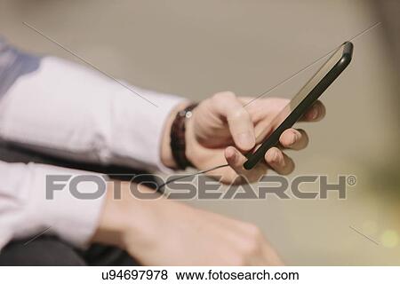 Hands of young businessman selecting music on smartphone View Large Photo Image Stock Photo - Hands of young businessman selecting music on smartphone. Fotosearch