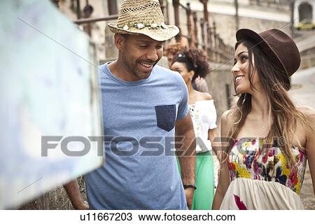 "Heterosexual couple walking along street, smiling" View Large Photo Image Stock Image - "Heterosexual couple walking along street, smiling". Fotosearch