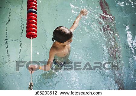 High angle view of boy holding onto rope in swimming pool View Large Photo Image Stock Image - High angle view of boy holding onto rope in swimming pool. Fotosearch