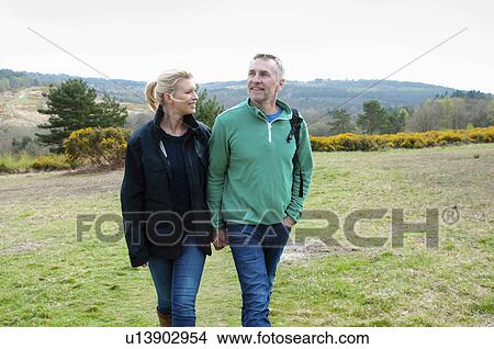 Picture - Hiking couple walking in rural landscape. Fotosearch