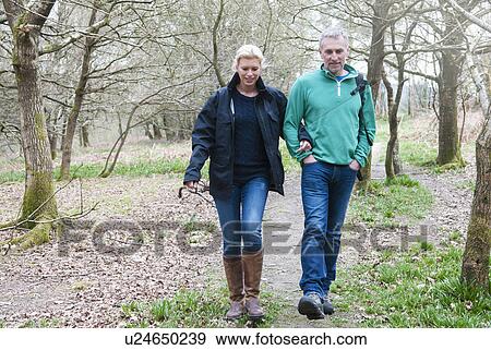 Stock Photo - Hiking couple walking in woods. Fotosearch