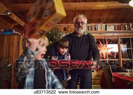 Joyful boy holding up Christmas present View Large Photo Image Stock Image - Joyful boy holding up Christmas present. Fotosearch