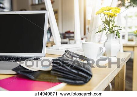 Stock Image - Laptop and open purse on table. Fotosearch