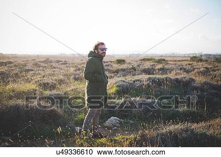 Lone mid adult man with hands in pockets in field View Large Photo Image Stock Image - Lone mid adult man with hands in pockets in field. Fotosearch