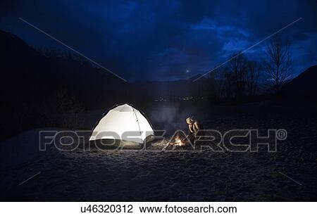 Man by campfire and tent at night View Large Photo Image Stock Image - Man by campfire and tent at night. Fotosearch