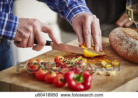 Stock Image - "Man chopping vegetables, close up". Fotosearch