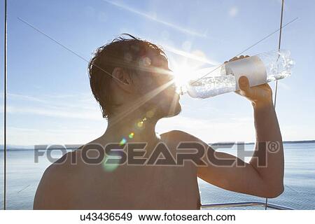 Man drinking on sailboat View Large Photo Image Stock Photo - Man drinking on sailboat. Fotosearch