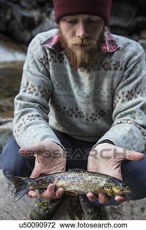 Man holding freshly caught fish View Large Photo Image Stock Image - Man holding freshly caught fish. Fotosearch