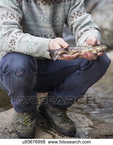 Man holding freshly caught fish View Large Photo Image Stock Photograph - Man holding freshly caught fish. Fotosearch