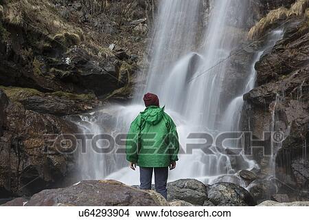 Picture - "Man looking at waterfall, River Toce, Premosello, Verbania, Piedmonte, Italy". Fotosearch