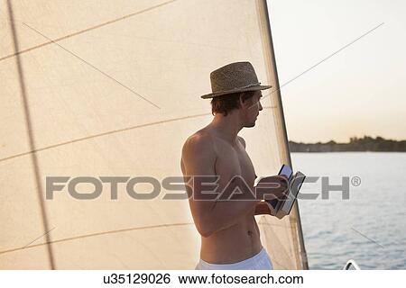 Stock Photograph - Man on sailboat. Fotosearch