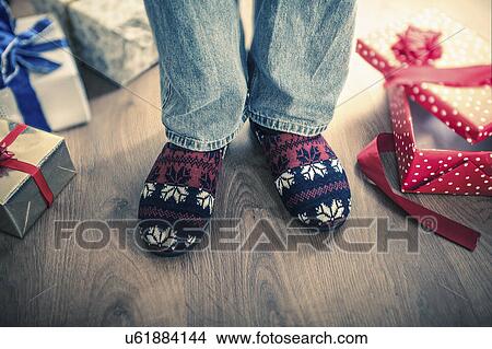 Man wearing slippers with christmas gifts on floor View Large Photo Image Picture - Man wearing slippers with christmas gifts on floor. Fotosearch