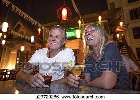 "Mature couple laughing in cocktail bar, Vientiane, Laos" View Large Photo Image Stock Photograph - "Mature couple laughing in cocktail bar, Vientiane, Laos". Fotosearch