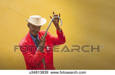 Stock Photo - "Mature male dancer poised in front of yellow wall, Havana, Cuba". Fotosearch